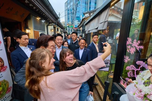 이재명 대통령이 21일 서울 종로구 익선동 한옥거리를 방문해 외국인 관광객과 기념촬영을 하고 있다 사진연합뉴스