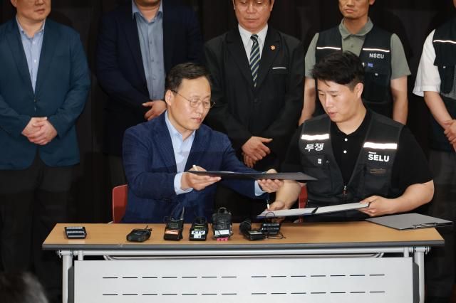 20일 경기도 수원시 장안구 경기고용노동청에서 열린 삼성전자 임금협상을 마친 후 여명구 삼성전자 DS디바이스솔루션·반도체 사업 담당 피플팀장과 최승호 삼성그룹 초기업노동조합 삼성전자지부 위원장이 잠정 합의안에 서명하고 있다 사진연합뉴스