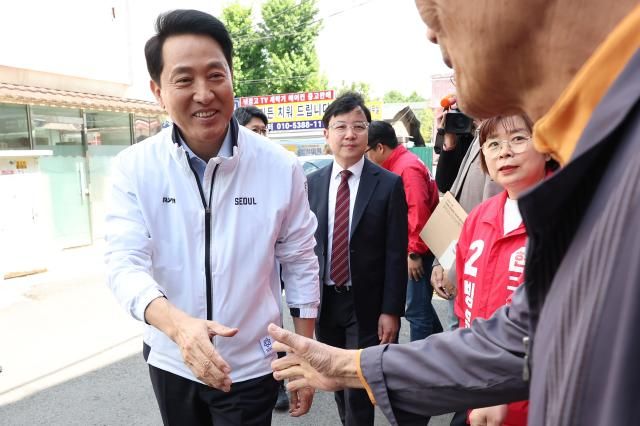 오세훈 국민의힘 서울시장 후보가 4일 서울 구로구 온수역 역세권 활성화 정비사업구역 준비추진위원회 앞에서 현장 간담회 참석자들과 인사하고 있다 사진연합뉴스