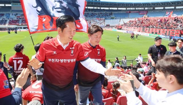 정청래 더불어민주당 대표왼쪽와 조용익 부천시장 후보가 5일 프로축구 K리그1 부천FC와 제주SK FC의 경기가 열린 경기 부천시 부천종합운동장을 찾아 관중들과 인사하고 있다 사진연합뉴스