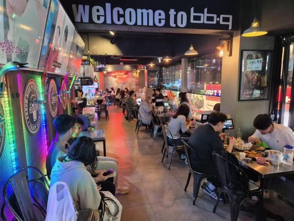 BBQ 홍대로데오점에서 외국인 관광객들이 BBQ 치킨을 먹고 있는 모습 사진BBQ