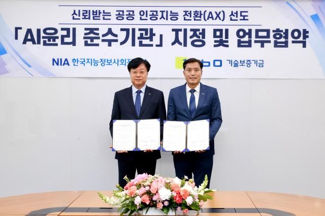 박주선 기보 전무이사와 김형철 한국지능정보사회진흥원장왼쪽이 업무협약 후 기념촬영을 하고 있다 사진기술보증기금