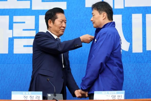 8일 국회에서 열린 더불어민주당 4차 인재 영입식에서 정청래 대표가 김영빈 변호사에게 민주당 상징인 파란 점퍼를 입혀주고 있다사진연합뉴스