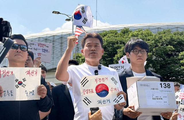 전 한국사 강사 전한길씨와 그의 지지자들이 12일 개표소 봉쇄 시위 현장인 서울 송파구 SK핸드볼경기장 앞에서 잠실7동 제2투표소에 보관돼 있다 사라진 투표용지 보관상자 중 1개를 제보를 통해 확보했다고 주장하며 상자를 공개하고 있다 사진연합뉴스