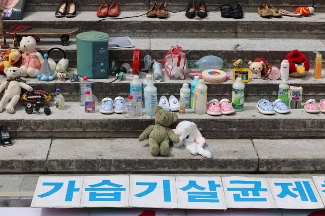 지난해 8월 28일 서울 종로구 세종문화회관 계단에서 열린 가습기살균제 참사 14주년 기자회견에서 태아 영유아 어린이 피해 추모를 위한 유품들과 가습기 살균제 등이 전시돼 있다 사진연합뉴스