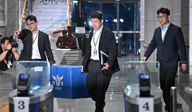 6·3 전국동시지방선거 투표용지 부족 사태를 들여다보고 있는 검경 합동수사본부 관계자들이 지난 11일 경기도 과천 중앙선거관리위원회에서 압수수색을 마친 뒤 압수품을 들고 나서고 있다 사진연합뉴스