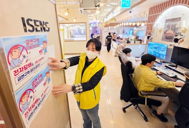 23일 오전 광주 북구 한 피시방에서 북구보건소 직원들이 실내 전자담배 흡연 금지 안내문을 붙이고 있다 개정된 담배사업법이 시행되는 오는 24일부터는 니코틴을 포함해 액상형 전자담배도 법적 담배에 포함돼 실내 흡연 시 과태료를 부과해야 한다 사진연합뉴스