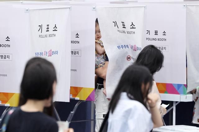 제9회 전국동시지방선거일인 3일 서울 잠전초 체육관에 마련된 잠실본동 제4·5·6투표소에서 한 아이가 기표소 밖을 보고 있다 사진연합뉴스