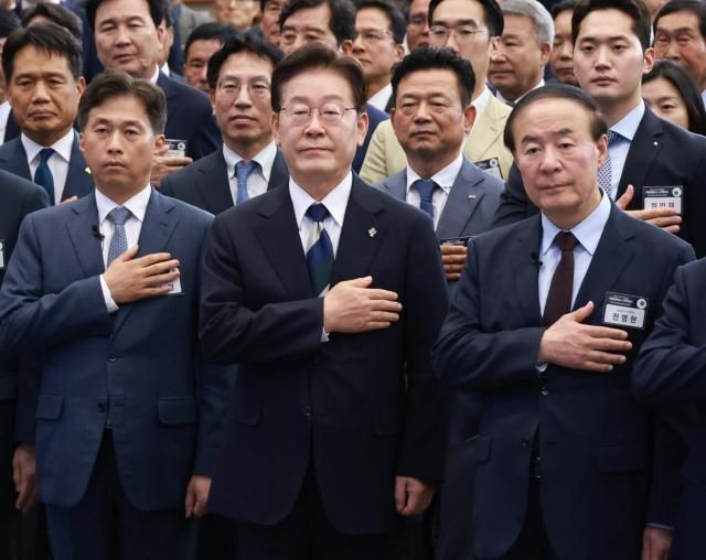 이재명 대통령이 30일 광주 김대중컨벤션센터에서 열린 서남권 첨단산업 발전비전 국민보고회에서 국민의례를 하고 있다 왼쪽부터 곽노정 SK하이닉스 대표 이재명 대통령 전영현 삼성전자 부회장 사진연합뉴스