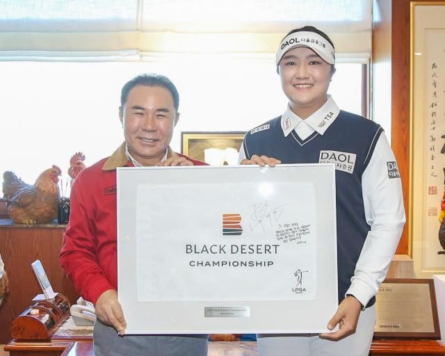 윤홍근 제너시스BBQ 그룹 회장왼쪽이 지난 1월 6일 유해란 프로에게 후원 감사 메시지가 담긴 LPGA 블랙데저트 챔피언십 기념 액자를 전달받고 있다 사진제너시스BBQ 그룹