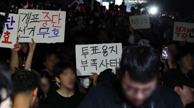 4일 제9회 전국동시지방선거 및 국회의원 재·보궐선거 투표용지 부족으로 투표 시간이 오후 10시까지 연장됐던 서울 송파구 잠실7동 제2투표소 앞에서 부정선거 등 손팻말을 든 시민들이 구호를 외치고 있다 사진연합뉴스