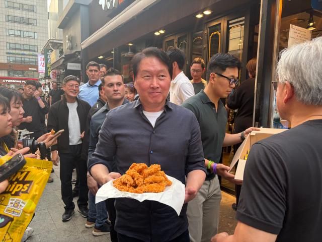 최태원 SK그룹 회장이 7일 서울 강남구 깐부치킨 삼성점에서 추진된 엔비디아와의 만찬에서 기다리고 있던 시민들에게 치킨을 나눠주고 있다 사진김나윤 기자