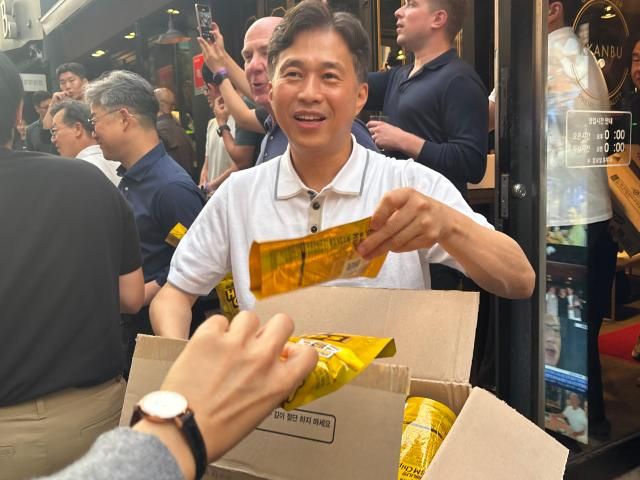 곽노정 SK하이닉스 사장이 7일 서울 강남구 깐부치킨 삼성점에서 추진된 엔비디아와의 만찬에서 기다리고 있던 시민들에게 HBM칩을 나눠주고 있다 사진김나윤 기자