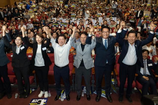 12일 국회 의원회관에서 열린 전국자치분권민주지도자회의KLDC에 더불어민주당 당 대표 후보 주자들과 자치분권회의 상임대표인 박승원 광명시장이 손을 들어 인사하고 있다사진연합뉴스
