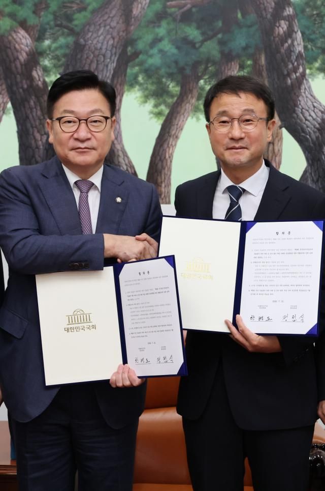 한병도 더불어민주당 대표 직무대행 겸 원내대표오른쪽와 정점식 국민의힘 원내대표가 21일 국회에서 선관위 투표용지 부족 사태에 따른 특검법안 합의문에 서명한 뒤 악수하고 있다 사진연합뉴스
