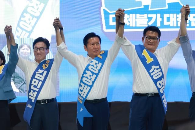 더불어민주당 김민석· 정청래·송영길 당 대표 후보가 9일 강원도 횡성국민체육센터에서 열린 민주당 대표·최고위원 후보자 강원 합동연설회에서 손을 잡고 기념 촬영하고 있다사진연합뉴스