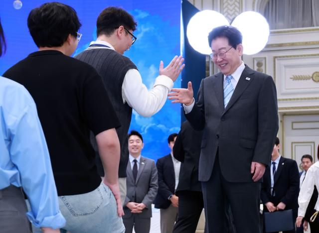 이재명 대통령이 19일 청와대에서 열린 청년의 날 기념식 행사에서 입장하는 청년들과 인사하고 있다 연합뉴스