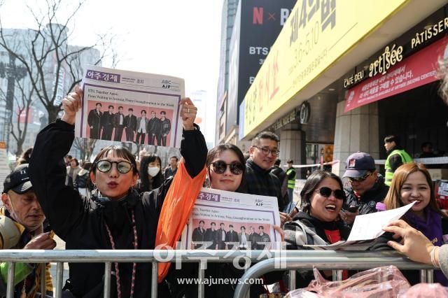 방탄소년단BTS 컴백 공연일인 21일 오전 서울 종로구 광화문광장에서 아미BTS 팬덤들과 시민들이 아주경제에서 발행한 BTS 특별판 호외를 받고 있다 2026321사진유나현 기자 shootingajupresscom