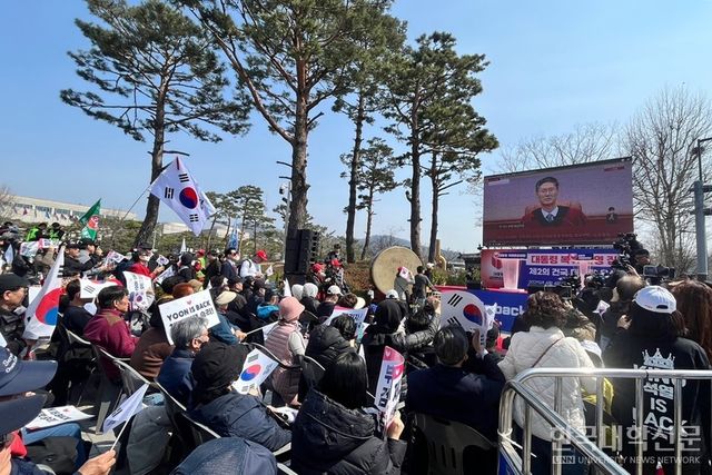 국민변호인단 집회 참가자들이 대형 스크린을 통해 헌법재판소의 선고를 지켜보고 있다. (사진=윤채빈 기자)