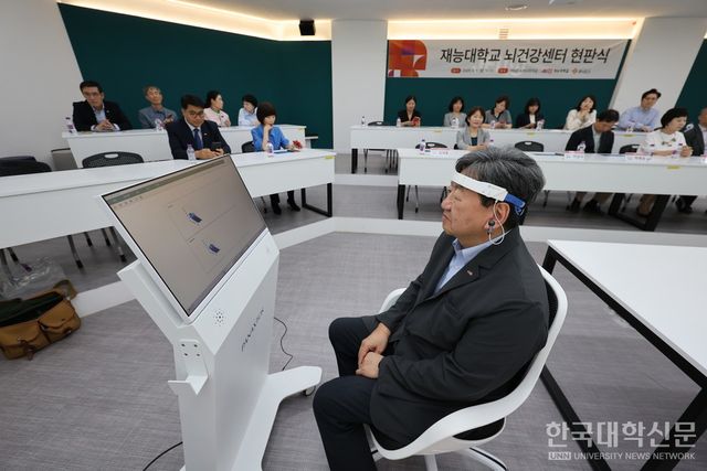 이남식 재능대학교 총장이 ㈜파낙토스가 개발한 웨어러블 EEG(뇌파 측정기기)를 착용하고 뇌파 분석 시연을 하고 있다. (사진=재능대학교)