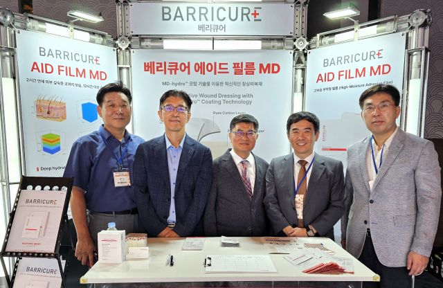 학술대회 행사장 부스에서 메디포와 지엔팜 참석자가 기념 촬영을 하고 있다