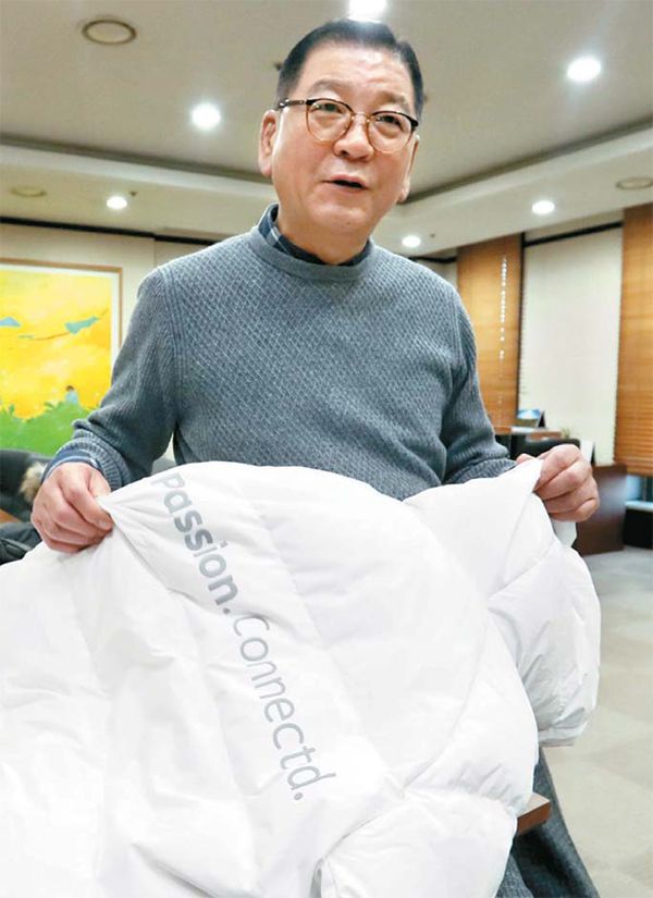 평창 동계올림픽 때 빅 히트를 한 롱패딩을 들고 있는 염태순 회장.