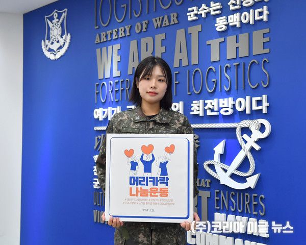 25일 해군군수사령부 정훈실에 근무하는 강승연 하사가 모발 기부 기념 피켓을 들고 기념사진을 촬영하고 있다. (사진/제공=해군)