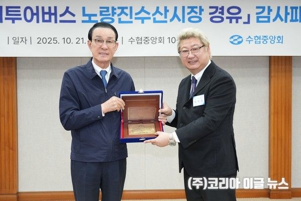 노동진 수협중앙회장이 서울시티투어버스 노선에 노량진수산시장을 유치해 낸 공로로 시장 상인회로부터 감사패를 수여받고 기념사진을 찍고 있다.&nbsp; (사진/제공=수협중앙회)