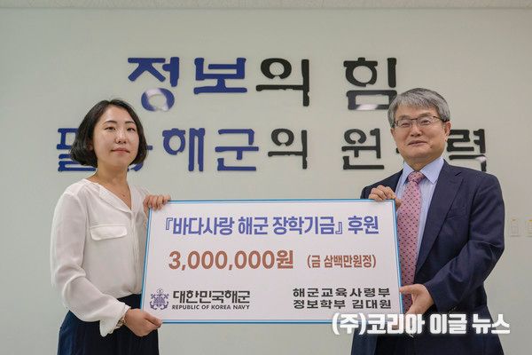 24일 해군교육사령부 전투병과학교에서 열린 기부금 전달식에서 김대원 정보판단 교관(왼쪽)이 바다사랑 해군 장학재단 이사(오른쪽)로부터 기부증서를 전달받고 있다. (사진/제공=해군)