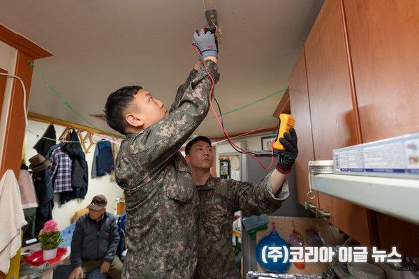 해군교육사령부 기술행정학교 전기교관인 소성한(왼쪽), 장준우(오른쪽) 상사가 홀로 지내는 어르신 가정을 방문하여 창고에서 전기 안전점검을 실시하고, 천장에 형광등을 설치하고 있다.&nbsp; (사진=중사 홍성민)
