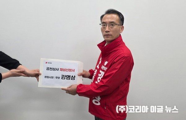 강명상 창원시장 예비후보가 결연한 표정으로 캠프 관계자로부터 '재심신청서'를 전달받고 있다.&nbsp;