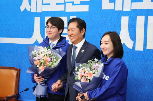 하정우(왼쪽) 전 청와대 AI미래기획수석과 전은수(오른쪽) 전 청와대 대변인이 29일 오전 서울 여의도 국회에서 열린 더불어민주당 2차 인재영입식에서 정청래 당대표로 부터 당점퍼를 받아 입고 기념촬영을 하고 있다.뉴시스