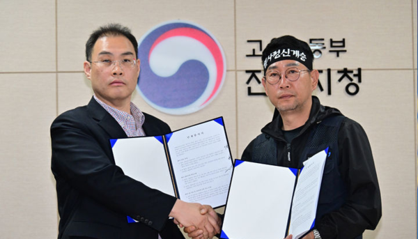 민주노총 공공운수노조 화물연대본부와 BGF로지스는 30일 오전 경남 진주시 고용노동부 진주지청에서 조인식을 열고 교섭을 통해 마련된 단체합의서에 서명했다. 사진은 화물연대 김동국 위원장과 BGF로지스 이민재 대표이사가 합의서를 들고 기념촬영을 하고 있다. 뉴시스