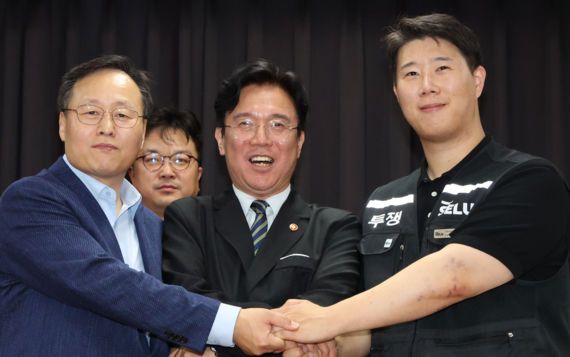 20일 경기 수원시 장안구 경기고용노동청에서 열린 삼성전자 임금협상을 마친 후 여명구 삼성전자 DS(디바이스솔루션·반도체 사업 담당) 피플팀장(왼쪽부터)과 김영훈 고용노동부 장관, 최승호 삼성그룹 초기업노동조합 삼성전자지부 위원장이 잠정 합의한에 서명한 후 손을 맞잡고 파이팅을 외치고 있다. 뉴시스