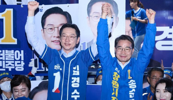 더불어민주당 김경수(왼쪽) 경남도지사 후보와 송순호 창원시장 후보가 지난 21일 저녁 창원특례시 성산구 상남분수광장에서 열린 창원지역 후보들 '원팀 출정식'에서 지지자들의 환호에 두 손 들어 인사하고 있다.뉴시스