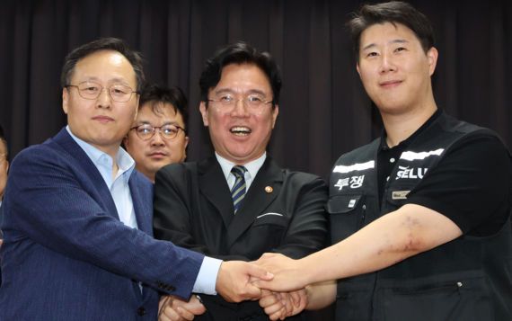 20일 경기 수원시 장안구 경기고용노동청에서 열린 삼성전자 임금협상을 마친 후 여명구 삼성전자 DS(디바이스솔루션·반도체 사업 담당) 피플팀장(왼쪽부터)과 김영훈 고용노동부 장관, 최승호 삼성그룹 초기업노동조합 삼성전자지부 위원장이 잠정 합의한에 서명한 후 손을 맞잡고 파이팅을 외치고 있다.뉴시스