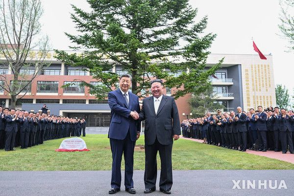시진핑(왼쪽) 중국 국가주석과 김정은 북한 국무위원장이 지난달 9일 평양의 조선노동당 중앙간부학교를 방문해 전나무 식수를 마친 후 악수하며 기념 촬영하고 있다. 뉴시스