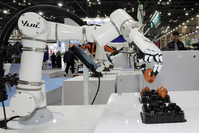 달걀을 옮기는 로봇. 지난 3월 11일 경기도 고양시 킨텍스 제1전시장에서 열린 '제27회 국제금형 및 관련산업전'에서 한 참관인이 달걀을 옮기는 로봇을 살펴보고 있다.(사진=연합뉴스)
