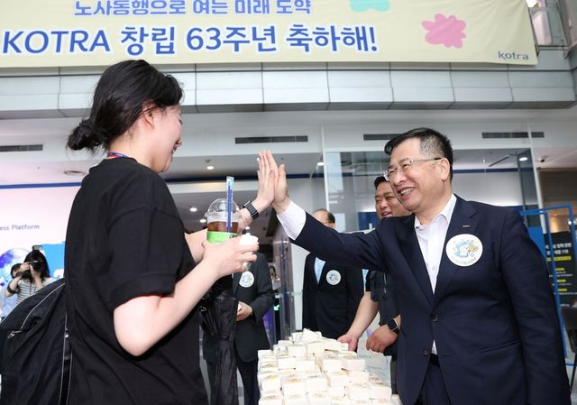 창립 63주년을 맞이하여 노사 합동으로 직원들과 출근길 하이파이브 및 감사 인사를 하고 있는 강경성 KOTRA 사장(오른쪽)의 모습. (사진=KOTRA)