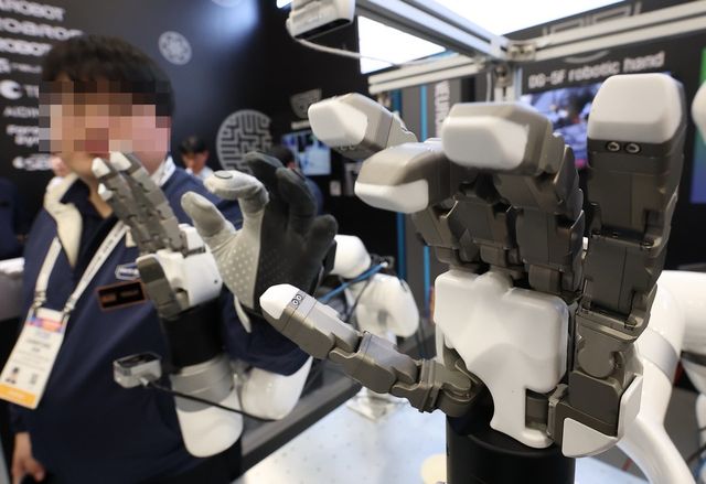 사람의 신체·인지 한계 극복...‘뇌에 칩 연결’ 기술 개발 추진. 사진은 CES 개막일인 1월 6일(현지시간) 미국 네바다주 라스베이거스 컨벤션센터(LVCC)에 한국 로봇 업체 테솔로 관계자가 장갑 움직임을 따라 똑같이 반응하는 로봇 팔을 시연하고 있는 모습. (사진=연합뉴스)