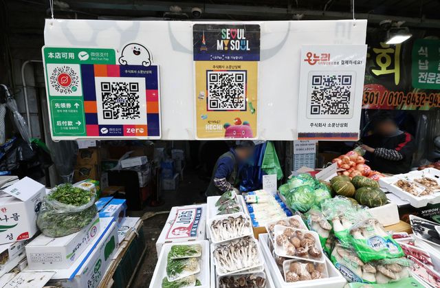 정부가 추경으로 국민 70%에게 지역화폐형 지원금을 지급한다. 사진은&nbsp;서울 마포구 망원시장의 한 상점에 서울페이와 온누리상품권 등 QR코드 안내문이 붙어있는 모습. (사진=연합뉴스)