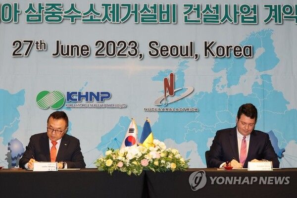 황주호 한국수력원자력 사장(왼쪽)과 코스민 기처 루마니아 원자력공사(SNN) 사장이 27일 오후 서울 포시즌스호텔에서 열린 루마니아 원전 삼중수소제거설비 건설 계약식에서 계약서에 서명하고 있다. [사진=연합뉴스]