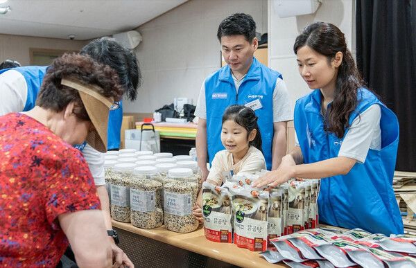 지난 5일 '찾아가는 나눔장터'에 방문한 어르신에게 우리은행 임직원과 가족이 준비한 여름나기 지원물품을 전달하고 있다. [사진=우리은행 제공]