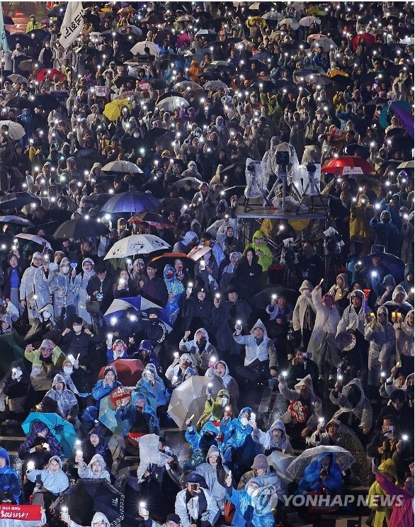 이재명 대표의 1심 판결 직후 16일 열린 첫 윤석열 규탄집회는 빗속에서도 열렸다.&nbsp;&nbsp;'김건희 특검 수용, 국정농단 규명! 윤석열을 거부한다 시민행진' 집회 참가자들이 휴대폰 불빛을 비추며 정권규탄 구호를 외치고 있다. [사진=연합뉴스]