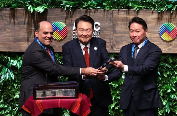 윤석열 대통령과 2025 경주 아시아태평양경제협력체(APEC) CEO&nbsp;서밋&nbsp;의장을 맡게 되는&nbsp;최태원&nbsp;대한상공회의소 회장이 15일(현지시간) 페루 리마 국립대극장에서 열린 APEC CEO&nbsp;서밋에서 페르난도 자발라 의장으로부터 의사봉을 인수하는 모습. [사진=연합뉴스]