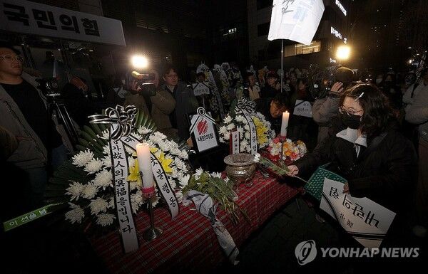 1일 오후 대구 수성구 국민의힘 대구시당 앞에서 열린 대구촛불행동 주최 '국짐당 국민 장례식'에 설치된 빈소에서 참석자가 헌화하고 있다. 2024.12.11 [사진=연합뉴스]