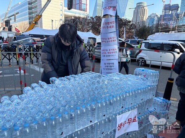 서울 여의도 국회의사당역 4번 출구 근처에서 ‘쓰레기는 윤석열과 김건희, 계엄세력만으로도 충분하다‘는 문구와 함께 생수를 무료나눔 하고 있다. [사진= 안다인 기자]