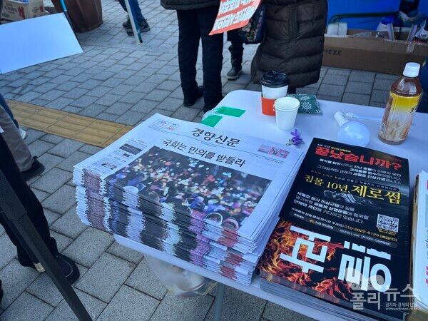서울 여의도 국회의사당역 4번 출구 근처에서 탄핵손 피켓과 경향신문 특별판을 나눠주고 있다. [사진= 안다인 기자]