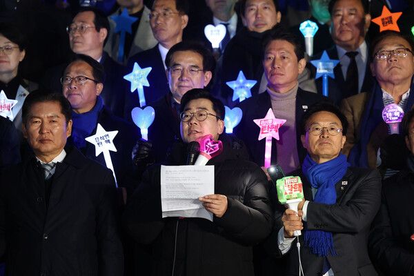 더불어민주당 박찬대 원내대표가 윤석열 대통령에 대한 2차 탄핵소추안 표결을 하루 앞둔 13일 오후 국회 본관 앞에서 응원봉을 들고 결의문을 낭독하고 있다. [사진= 연합뉴스]