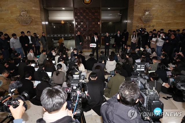 한동훈 대표가 14일 탄핵안이 가결된 이후 열린 국민의힘 의원총회에서 심야 회의를 마치고 기자들의 질문에 답하고 있다. [사진=연합뉴스]